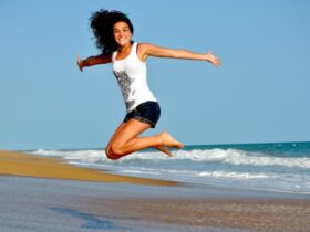 Chica saltando en la playa