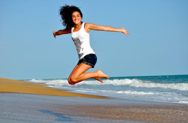 Chica saltando en la playa