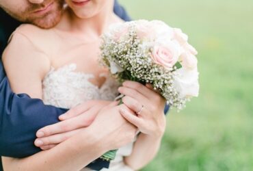 Pareja abrazándose vestidos de boda
