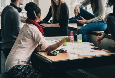 Estudiantes reunidos al rededor de mesa de trabajo