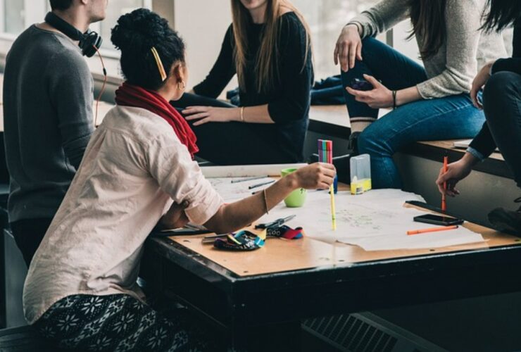 Estudiantes reunidos al rededor de mesa de trabajo
