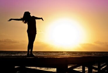 Mujer delante de puesta de sol en paz