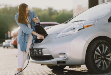 Chica cargando coche electrico