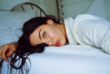 Chica de ojos claros tumbada en la cama