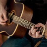 Persona aprendiendo a tocar guitarra acústica