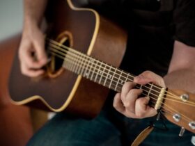 Persona aprendiendo a tocar guitarra acústica